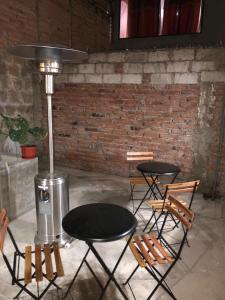a room with two tables and chairs and a brick wall at Tiki Hostel in Riobamba