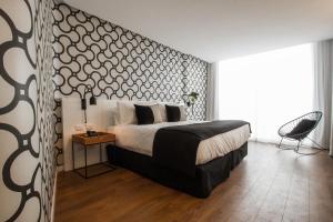 a bedroom with a large bed and a chair at CasaSur Palermo Hotel in Buenos Aires