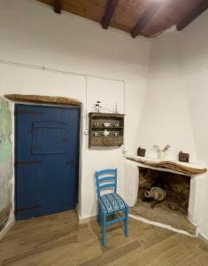 una silla azul en una habitación con puerta azul en B&B Corte San Lussorio, en Oliena