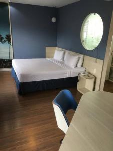 - une chambre avec un lit et un mur bleu dans l'établissement Flat no Mercure Navegantes, à Récife