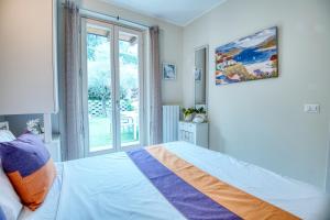 Schlafzimmer mit einem Bett und einem Fenster in der Unterkunft Panorama lake view, pool & garden, 2 bathrooms, kingsize & single-beds, fast Internet in Toscolano-Maderno
