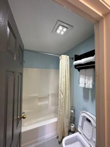 a bathroom with a toilet and a bath tub at Welcome Inn in North Kingstown