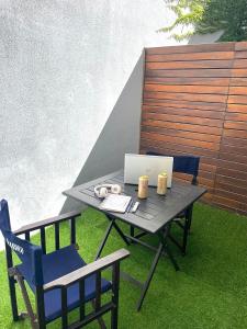 een terrastafel met een laptop en 2 stoelen bij Alfonsina Hostel in Buenos Aires