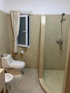a bathroom with a toilet and a shower at Nyumbani Tamu in Watamu