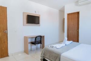ein Schlafzimmer mit Bett, Schreibtisch und Fernseher in der Unterkunft Hotel Cintra in Arcoverde