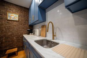 a kitchen with a stainless steel sink and blue cabinets at Apt in the heart of Main Street in Stroudsburg
