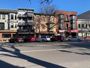 a city street with cars parked in front of buildings at Apt in the heart of Main Street in Stroudsburg