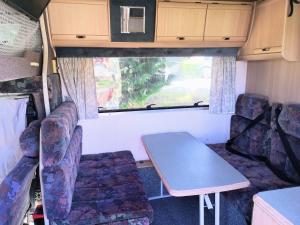 a dining room with a table and chairs in an rv at Motorhome Experience in Queenstown