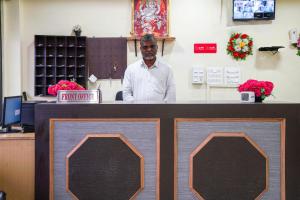 a man is standing behind a counter in a practition at 69076 OYO Hotel Sweekar in Shamshabad