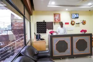 a man standing at the counter of a restaurant at 69076 OYO Hotel Sweekar in Shamshabad