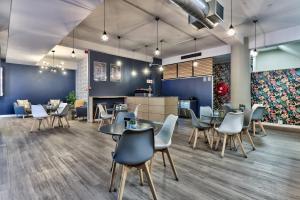 een restaurant met tafels en stoelen en een bar bij WINK Aparthotel One Thibault in Kaapstad