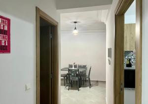 Bord de Mer: Appartement à 500m de la Plage & Surf في أغادير: مطبخ وغرفة طعام مع طاولة وكراسي +7 صور