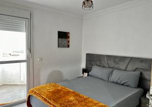 Bord de Mer: Appartement à 500m de la Plage & Surf في أغادير: غرفة نوم بسرير مع أريكة ونافذة