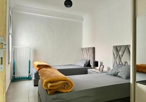 Bord de Mer: Appartement à 500m de la Plage & Surf في أغادير: غرفة معيشة بها سريرين وأريكة