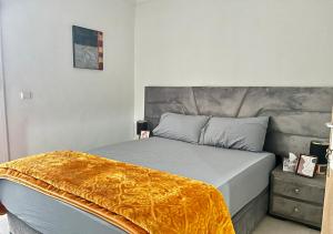 Bord de Mer: Appartement à 500m de la Plage & Surf في أغادير: غرفة نوم عليها سرير مع بطانية صفراء