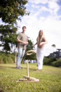 a man and a woman standing in a field with a disc at Reflections Forster Beach - Holiday Park in Forster