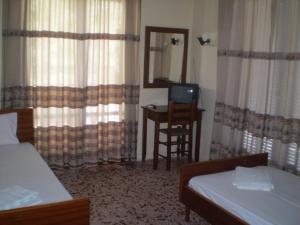 een slaapkamer met een bed, een bureau en een spiegel bij Hotel Apolafsi in Volos