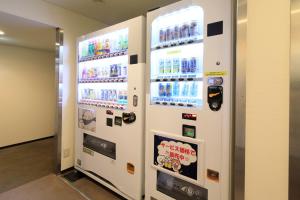 un distributeur automatique de boissons gazeuses dans un bâtiment dans l'établissement Hotel Shinjukuya, à Machida