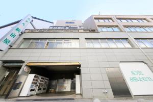 un grand bâtiment avec une porte d'entrée pour un bâtiment dans l'établissement Hotel Shinjukuya, à Machida