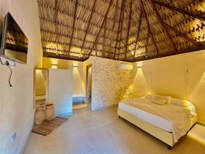 una camera con letto e tetto di paglia di Awa de Mar Playa a Tolú