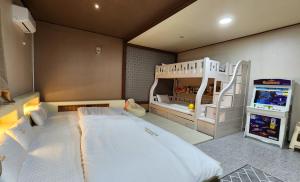 - une chambre avec des lits superposés et une salle de jeux dans l'établissement GyeongJu Kids & Family Hotel, à Gyeongju