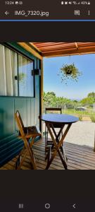 ein Picknicktisch und zwei Stühle auf einer Veranda in der Unterkunft Container com clima de montanha! in Siderópolis