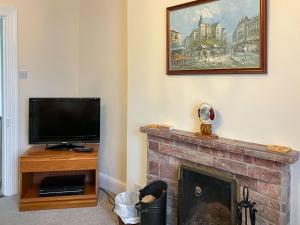 a living room with a fireplace and a television at Atlantic House - 27665 in Port Isaac
