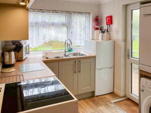 a kitchen with a sink and a refrigerator at Atlantic House - 27665 in Port Isaac
