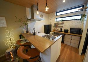 a kitchen with a sink and a counter with stools at RGH ISHIUCHI BASE - Vacation STAY 15899 in Hiroshima