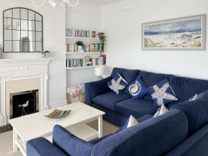 a living room with a blue couch and a fireplace at Anchor Loft in Fowey