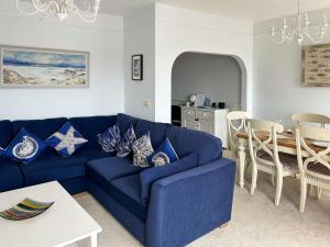 a blue couch in a living room with a table at Anchor Loft in Fowey
