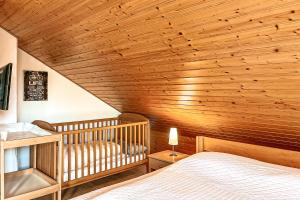 - une chambre avec un lit bébé et un plafond en bois dans l'établissement Urlauberdorf Haus 47d, à Boltenhagen