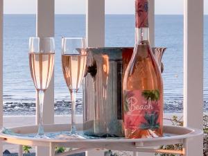 a bottle of champagne and two glasses on a table at Beach View House in Margate