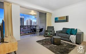een woonkamer met een bank en een balkon bij KIDS STAY FREE in Hinterland View 2 Bedroom 1 Bathroom Apartment at Chevron Renaissance- Q STAY in Gold Coast