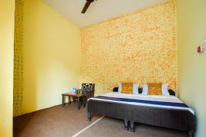 una camera con un letto e una parete gialla di SPOT ON Saini Guest House a Roorkee