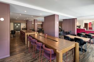 a restaurant with wooden tables and purple chairs at Mercure Perth On Hay in Perth