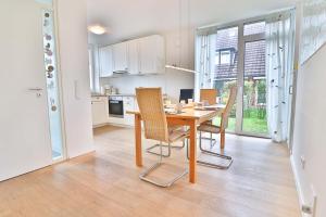 a kitchen and dining room with a table and chairs at Orange Hygge Haus in Langeoog