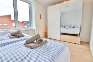 een slaapkamer met 2 bedden en handdoeken bij Orange Hygge Haus in Langeoog