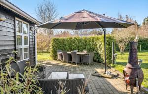 un patio con sombrilla, mesa y sillas en Amazing Home In Hjby With Wifi, en Højby