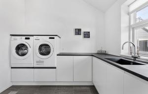 een witte keuken met een wasmachine en een wastafel bij Gorgeous Home In Jerup With Sauna in Jerup