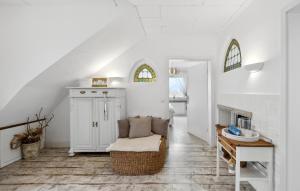 een witte woonkamer met een stoel en een tafel bij Pet Friendly Apartment In Carolinensiel With House A Panoramic View in Carolinensiel