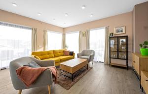 uma sala de estar com um sofá amarelo e duas cadeiras em Holiday Home Tina em Oklaj