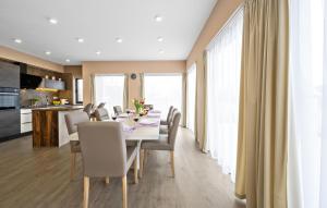 a dining room and kitchen with a table and chairs at Holiday Home Tina in Oklaj