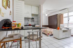 a kitchen with a counter and some chairs in it at Loft completo na Asa Sul próximo da P Federal ENAP LBV Aeroporto CASV , Rodov Interestadual e parque da cidade in Brasília