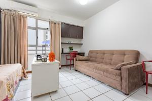een woonkamer met een bank en een keuken bij Loft completo na Asa Sul próximo da P Federal ENAP LBV Aeroporto CASV , Rodov Interestadual e academia da PM in Brasilia