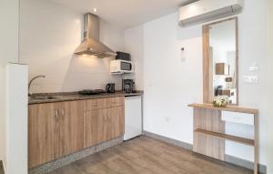 cocina con paredes blancas y armarios de madera en Gorgeous Apartment In Fuente De Piedra With Wifi en Fuente de Piedra