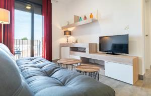 sala de estar con sofá azul y TV en Stunning Apartment In Fuente De Piedra With Outdoor Swimming Pool en Fuente de Piedra