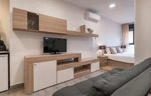 a living room with a tv and a couch and a bed at Cozy Apartment In Fuente De Piedra With Swimming Pool in Fuente de Piedra