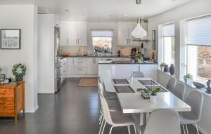 BrekkestøにあるAmazing Home In Brekkestø With Wifiのキッチン(白いテーブル、椅子付)