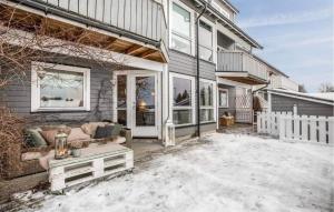 a house with a couch on a snow covered yard at Cozy Home In Heggedal With House A Panoramic View in Asker